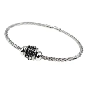 Detailed view of a stainless steel wire bangle featuring a gothic skull charm.