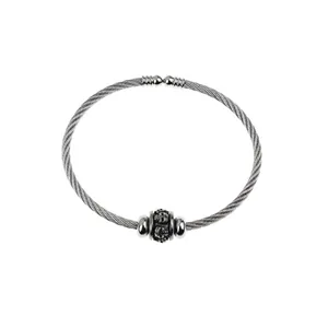 Close-up of stainless steel cable cuff bracelet with skull charm and twisted wire design
