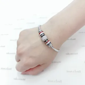 Primer plano de pulsera de resorte de acero inoxidable con cuentas de rayas tricolor