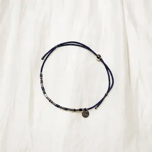 Détail du cordon bleu marine réglable et des perles en acier inoxydable du bracelet