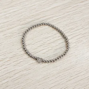 Close-up detail of stainless steel beaded bracelet featuring a heart charm with letter A