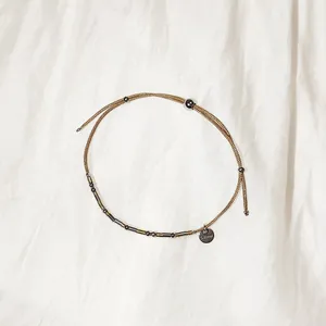 Vue détaillée d'un bracelet réglable en perles d'acier inoxydable et cordon tissé pour femme