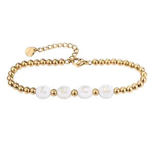 Detailansicht eines vergoldeten Edelstahl-Perlenarmbands mit weißen LUCK-Muschelperlen.