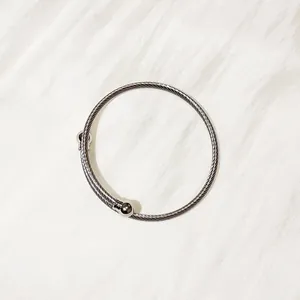 Close-up of stainless steel twisted cable bangle with polished ball end tips.
