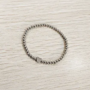 Detailed view of a silver stainless steel beaded bracelet with a heart initial B charm.