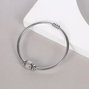 Detalle de un brazalete de cadena de serpiente de acero inoxidable con cierre magnético.
