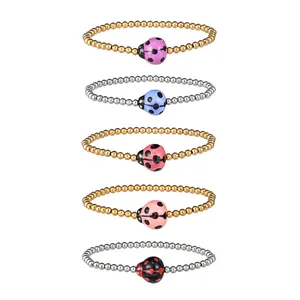 Set of five colorful ceramic ladybug charms on gold and silver beaded elastic bracelets.