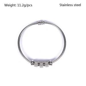 Vista detallada de pulsera de resorte de acero inoxidable con cuentas magnéticas.