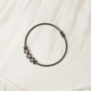Primer plano detallado de una pulsera de resorte de acero inoxidable con cuentas plata