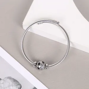 Detailed view of stainless steel wire cuff bracelet featuring silver soccer ball charm