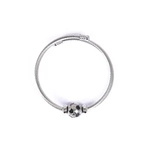 Close-up of stainless steel wire cuff bracelet featuring a detailed soccer ball bead accent
