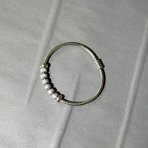 Detalle de pulsera de cadena de serpiente de acero inoxidable plata con cuentas texturizadas.