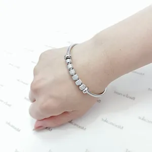 Vista detallada de la pulsera magnética de acero inoxidable plateado en la muñeca