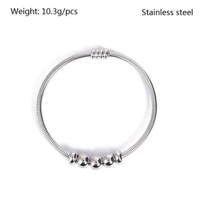 Primer plano de un brazalete de acero inoxidable con cinco cuentas móviles pulidas