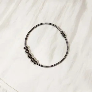 Detalle de una pulsera de resorte de acero inoxidable con cuentas y cierre magnético