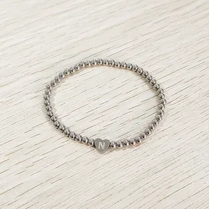 Detailed view of stainless steel beaded bracelet featuring a heart charm with letter N