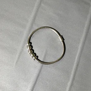 Pulsera de resorte de acero inoxidable plateada con cinco cuentas móviles detalle