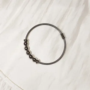 Primer plano de pulsera de resorte de acero inoxidable con perlas magnéticas