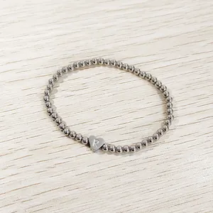 Close-up of stainless steel beaded bracelet featuring a heart-shaped 'R' initial charm