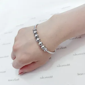 Primer plano de una pulsera de resorte de acero inoxidable con cuentas metálicas