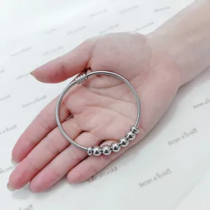 Detalle de una pulsera de resorte minimalista de acero inoxidable con cuentas plateadas
