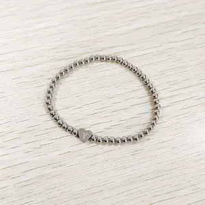 Macro view of a silver stainless steel bead bracelet with a heart 'Y' initial charm.