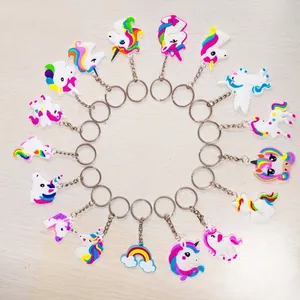 Verschiedene Cartoon Einhorn und Regenbogen PVC Schlüsselanhänger im Kreis auf Holzgrund.