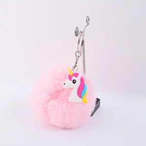 Vue détaillée d'un porte-clés pompon en fausse fourrure rose avec une licorne colorée