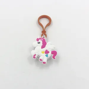 Primo piano di un portachiavi a forma di unicorno in PVC bianco e rosa