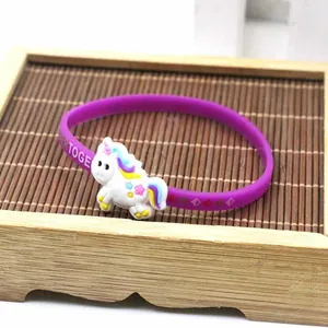 Primo piano di un braccialetto sportivo in silicone viola con un grazioso ciondolo unicorno 3D