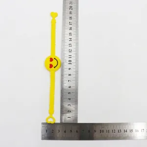 Detailed macro view of yellow PVC emoji bracelet with measurement ruler showing size