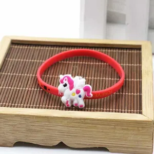 Dettaglio del braccialetto unicorno in silicone rosso con incisione Forever su legno