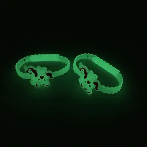 Dettaglio del ciondolo a forma di unicorno verde luminoso su bracciale in silicone.