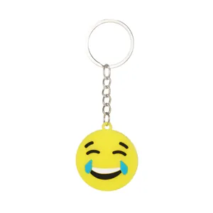 Dettaglio di un portachiavi emoji che ride in silicone giallo con anello in metallo