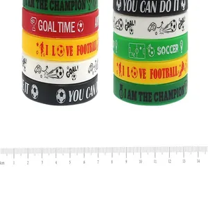 Detailed view of colorful soccer themed silicone wristbands with a ruler for scale