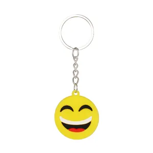 Vista dettagliata di un portachiavi in silicone giallo con faccina e anello in metallo.