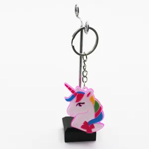 Detailansicht eines bunten Einhorn-Schlüsselanhängers aus weichem PVC auf einem Ständer