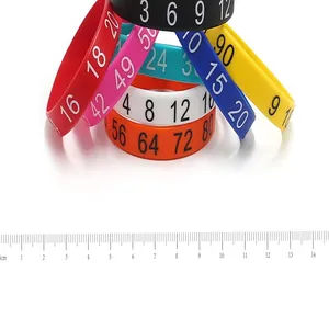 Detail shot of colorful printed silicone wristbands with a CM ruler for size reference.