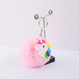 Gros plan d'un porte-clés pompon rose avec une breloque licorne en PVC colorée détail