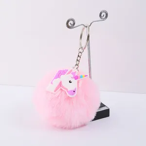 Gros plan détaillé d'un porte-clés à pompon rose avec une breloque licorne en PVC
