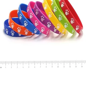 Colorful silicone wristbands with paw prints, measured with a centimeter ruler for size