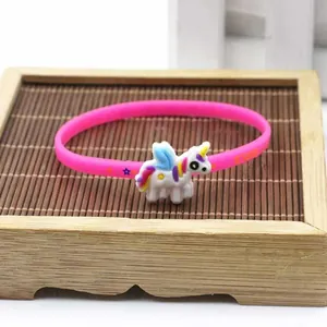 Primo piano di un braccialetto in silicone rosa con ciondolo a forma di unicorno colorato