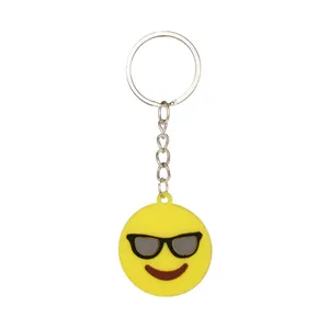 Dettaglio di un portachiavi emoji giallo in silicone con design occhiali da sole