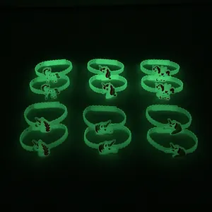 Vista dettagliata che mostra l'effetto fluorescente verde dei braccialetti in silicone unicorno.