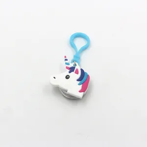 Dettaglio di un portachiavi a forma di unicorno in PVC bianco con clip blu e luce a LED