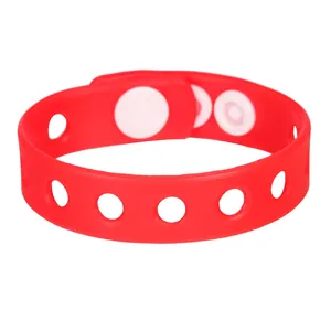 Gedetailleerd overzicht van een rode verstelbare siliconen armband met witte drukknopen en riem