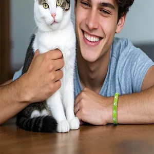 Green silicone wristband with white paw print patterns shown on a man holding a cute pet cat