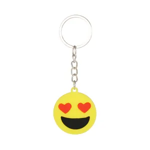 Dettaglio di un portachiavi emoji giallo con occhi a cuore, catena e anello argento.