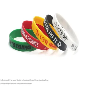 Detail of colorful football silicone wristbands with motivational sports slogans.