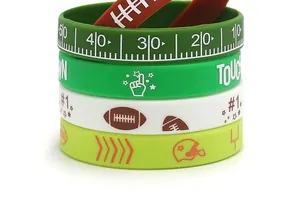 Close-up of American football themed silicone wristbands with touchdown and yard patterns.